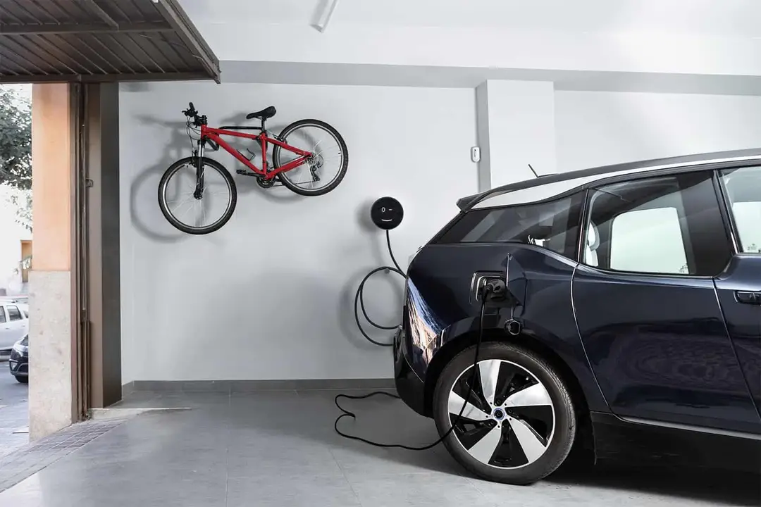 Modern otthoni garázs fali elektromos ZENTX telepített Voltie autó töltővel és rendezett tárolással.